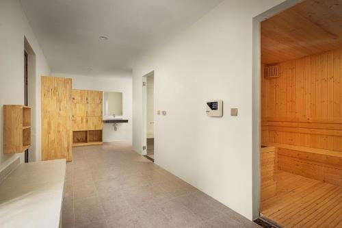 a hallway with white walls and wooden doors at Vakara Hotel Kep in Kep