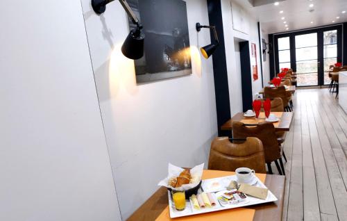 a restaurant with two tables and chairs and a table with food at Hotel Midi-Zuid in Brussels