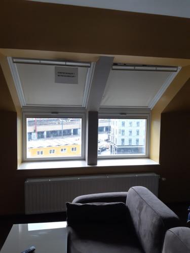 a living room with two windows and a couch at Hotel Midi-Zuid in Brussels