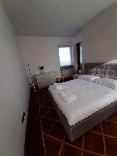 a bedroom with a large bed with white sheets at B&B Casa Lilla in Verzuolo