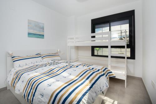 a bedroom with a white bunk bed and a window at Appartment Torre del Mar - 003 in Torre del Mar