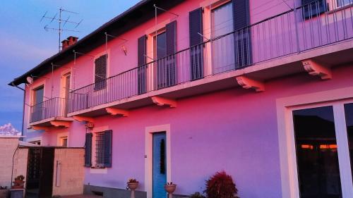 a pink building with a balcony at B&B Casa Lilla in Verzuolo