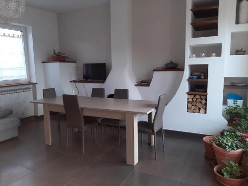 uma sala de jantar com uma mesa de madeira e cadeiras em B&B Casa Lilla em Verzuolo