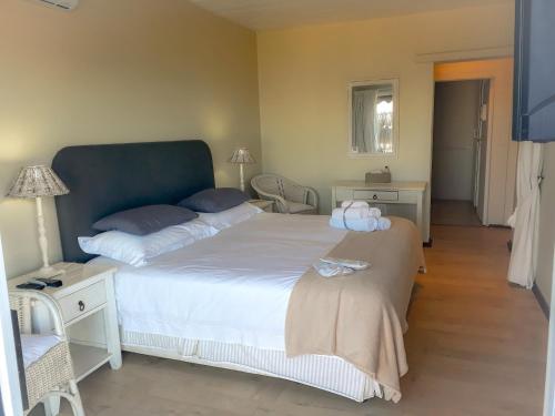 a bedroom with a large bed with a blue headboard at Whales Way Ocean Retreat in Wilderness