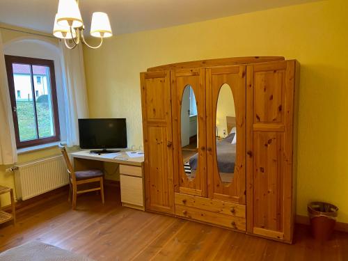 德伯爾恩的住宿－Kornkäfer Kleinmockritz，客房设有木制橱柜和一张带电脑的书桌。