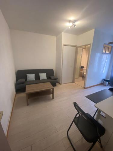 ein Wohnzimmer mit einem Sofa und einem Couchtisch in der Unterkunft Arcole 2-Studio Beziers Centre -Wifi - Tv connectée in Béziers