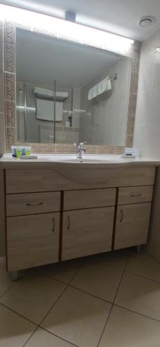 a bathroom with a sink and a large mirror at Beth-Shalom in Haifa