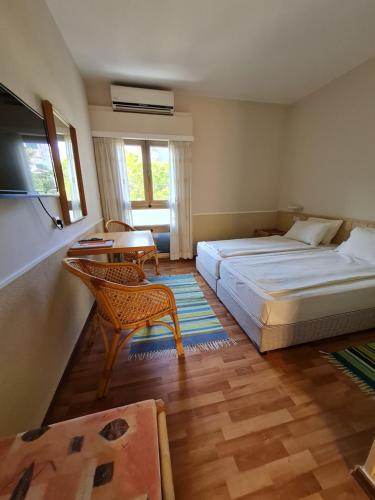 1 Schlafzimmer mit 2 Betten, einem Tisch und einem Stuhl in der Unterkunft Beth-Shalom in Haifa