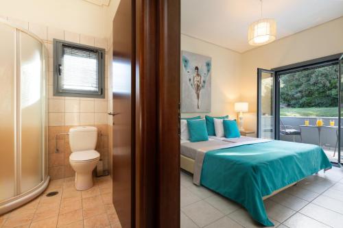 a bedroom with a bed and a bathroom with a toilet at Villa Iremia by Rodostamo Collection in Gazátika