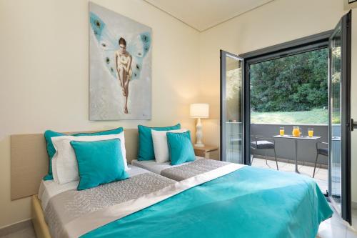 a bedroom with a large bed with blue pillows at Villa Iremia by Rodostamo Collection in Gazátika