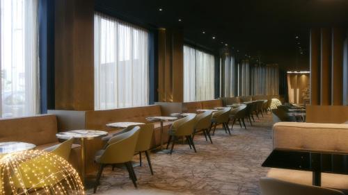 a row of tables and chairs in a restaurant at Howard Hotel Paris Orly Airport in Paray-Vieille-Poste