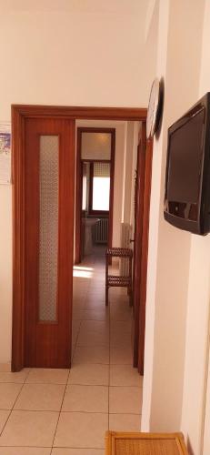a hallway with a door and a tv on a wall at Appartamento Marcella a due passi dal mare in Marcelli