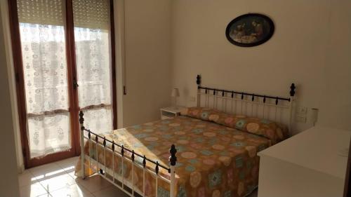 um quarto com uma cama e um relógio na parede em Appartamento Marcella a due passi dal mare em Marcelli