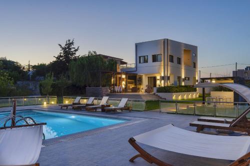 a house with a swimming pool in front of a house at Villa Sfedami in Mikro Metochi