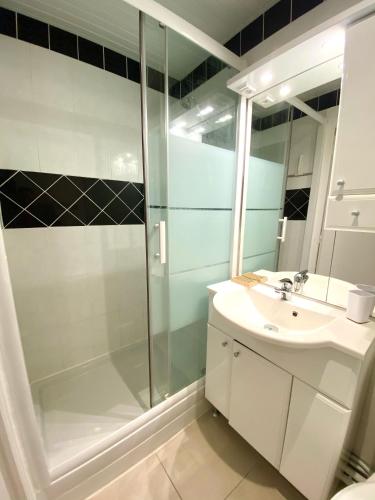 une salle de bain avec douche et lavabo dans l'établissement Albiréo, appt cosy en front de mer, à Luc-sur-Mer
