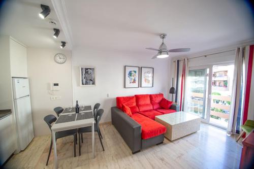 - un salon avec un canapé rouge et une table dans l'établissement "El Balcón de Huelva" lujo en pleno centro, à Huelva