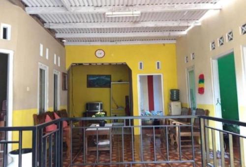 a room with a balcony with a yellow wall at Toto Homestay in Magelang