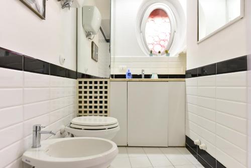 a white bathroom with a toilet and a sink at Appartamento Piazza Navona in Rome