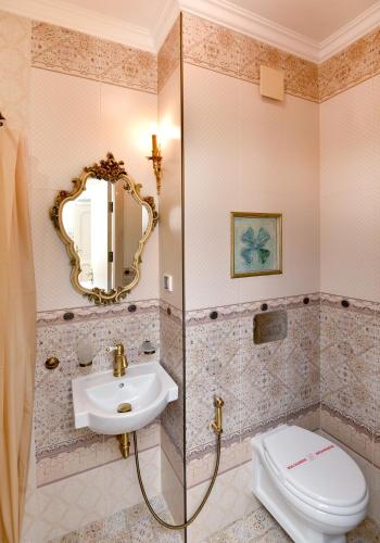 a bathroom with a sink and a toilet and a mirror at Royal Hotel in Varna City