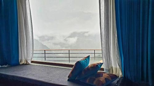 a room with a window with a view of a balcony at Casa Himalaya, Auli in Joshīmath