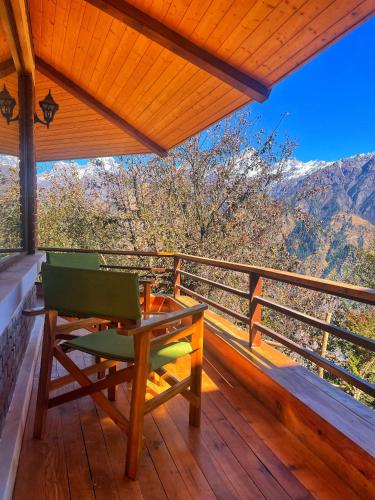 a wooden deck with a table and a bench on it at Casa Himalaya, Auli in Joshīmath