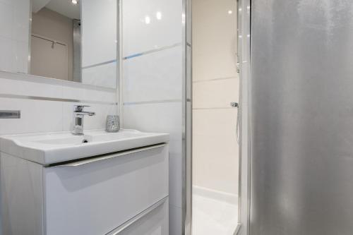 une salle de bain blanche avec un lavabo et une douche dans l'établissement love secret port nature 7, au Cap d'Agde