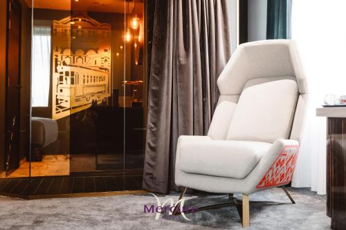 a white chair sitting in a living room at Mercure Timisoara in Timişoara