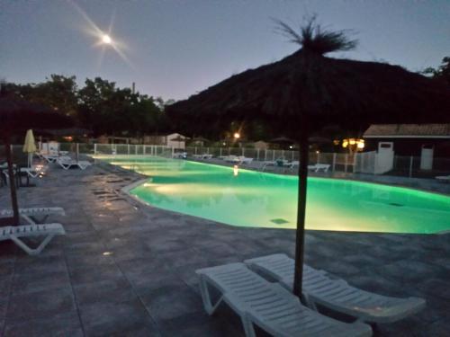a swimming pool with chairs and an umbrella at CAMPING Bassin Arcachon - LES GOELANDS in Arès