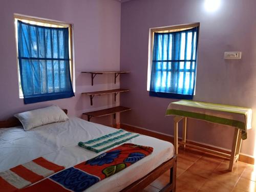 - une chambre avec un lit et 2 fenêtres dans l'établissement Om Ganesh Guest House Cliffside, à Arambol