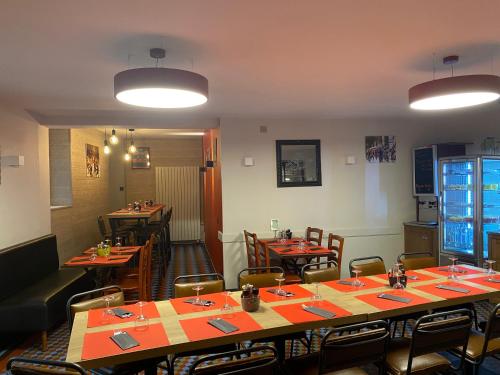 a dining room with tables and chairs in a restaurant at Hotel le Faisan in Saint-Avertin