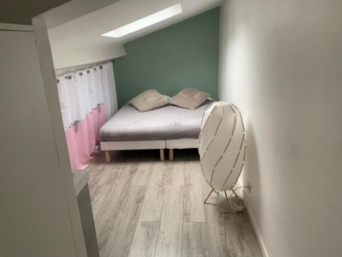een kleine slaapkamer met een bed en een ventilator bij Loft Porte de Gentilly in Gentilly
