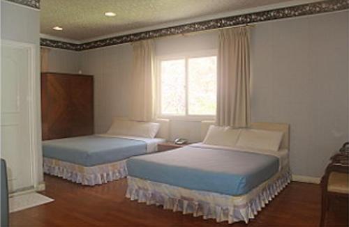 Hsin-hsien-ts'un的住宿－富仙境，一间卧室设有两张床和窗户。