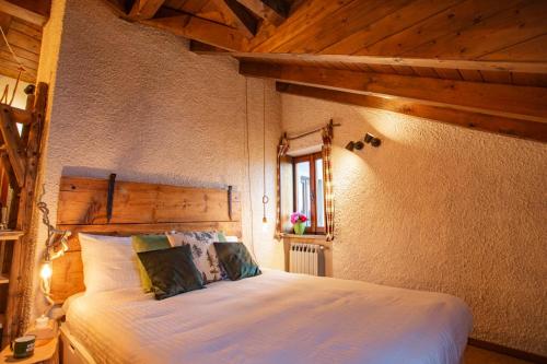 1 dormitorio con 1 cama blanca grande y techo de madera en Sequoia Loft - Family Apartment Lago Maggiore, en Trarego Viggiona