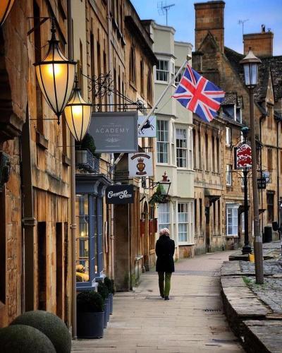 a person walking down a street with a british flag at Cotswold Chic Retreats "Jacinabox" Central Chipping Campden-Parking-Garden in Chipping Campden