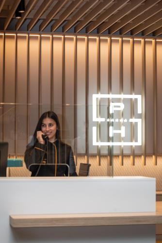 a woman taking a picture of herself in a mirror at Suites Plaza Hotel & Wellness in Andorra la Vella