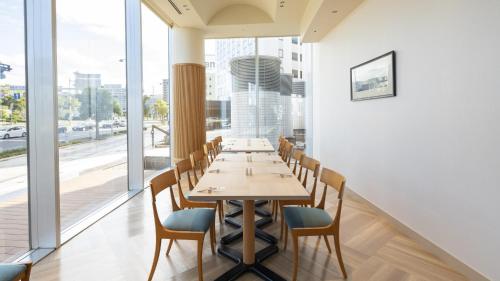 a dining room with a long table and chairs at JR Hotel Clement Takamatsu in Takamatsu