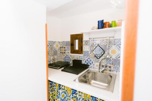 cocina con fregadero y azulejos en la pared en Nonna Titti, en Amalfi