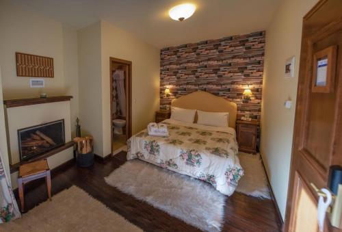 a bedroom with a bed and a brick wall at Villa Virginia Hotel in Karpenision