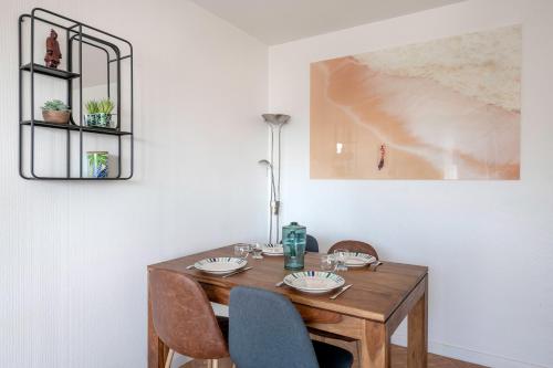 une salle à manger avec une table et des chaises en bois dans l'établissement Bel appartement - 400m plage de la Baule, à La Baule