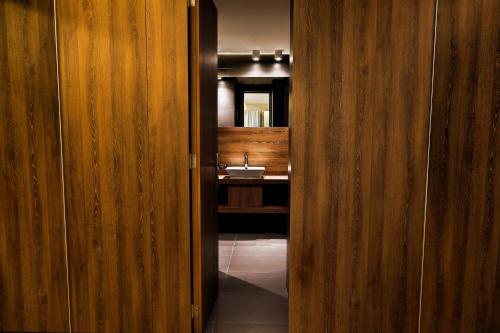 a hallway to a bathroom with a sink and a mirror at Le Pave Residences in Bayt al Kūkū