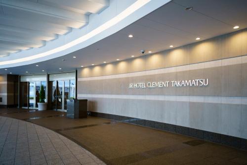 a lobby of a building with a sign on the wall at JR Hotel Clement Takamatsu in Takamatsu