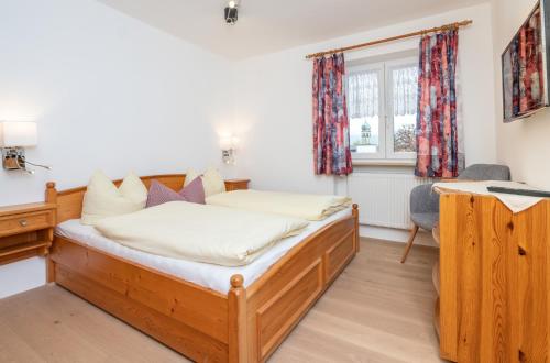 a bedroom with a bed and a desk at Gästehaus Kochelsee in Kochel