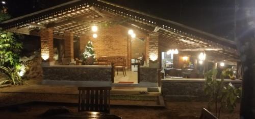 una casa con un patio iluminado por la noche en The Nature Kuruwita, en Ratnapura