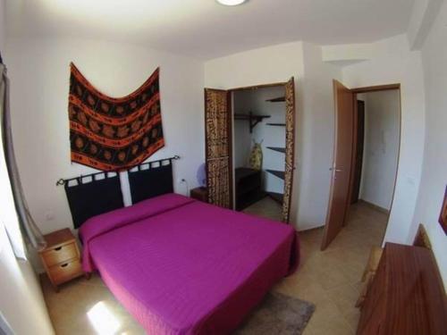 1 dormitorio con cama morada y espejo en Casa Bahia 8 en Santa Maria