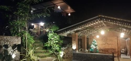 una casa con un árbol de Navidad delante de ella por la noche en The Nature Kuruwita, en Ratnapura