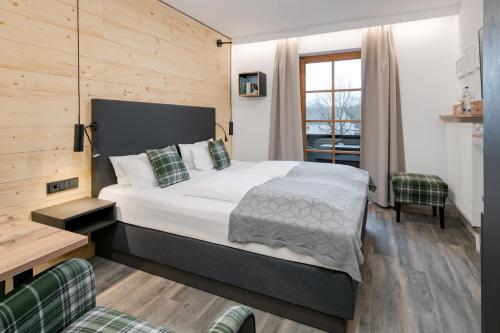 - une chambre avec un grand lit et une fenêtre dans l'établissement Hotel Neuer am See, à Prien am Chiemsee