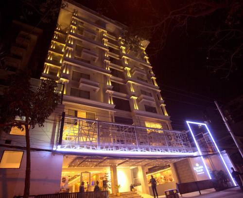 un edificio alto con luces encendidas por la noche en Golden Tulip The Grandmark Dhaka en Dhaka