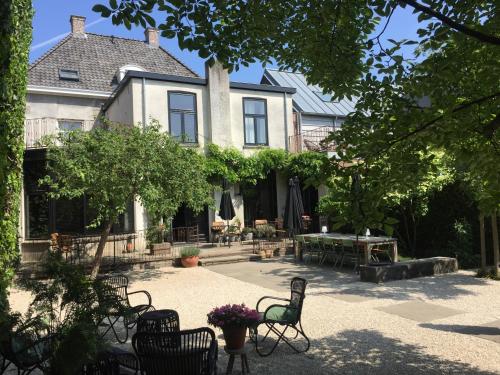 a house with chairs and a table in front of it at The Yard hotel Zuidkade in Veghel