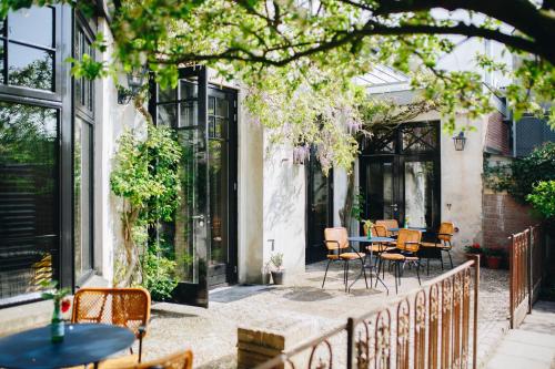 a patio with tables and chairs in a building at The Yard hotel Zuidkade in Veghel