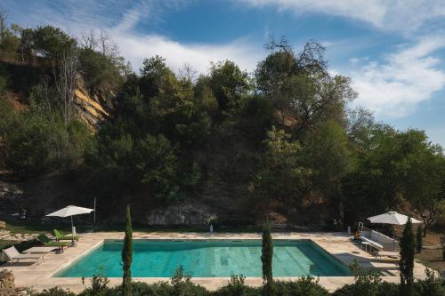 a swimming pool with chairs and umbrellas at Villa Pietra Viva in Lucignano